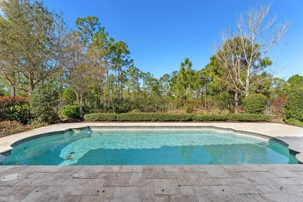 a swimming pool with outdoor seating and garden