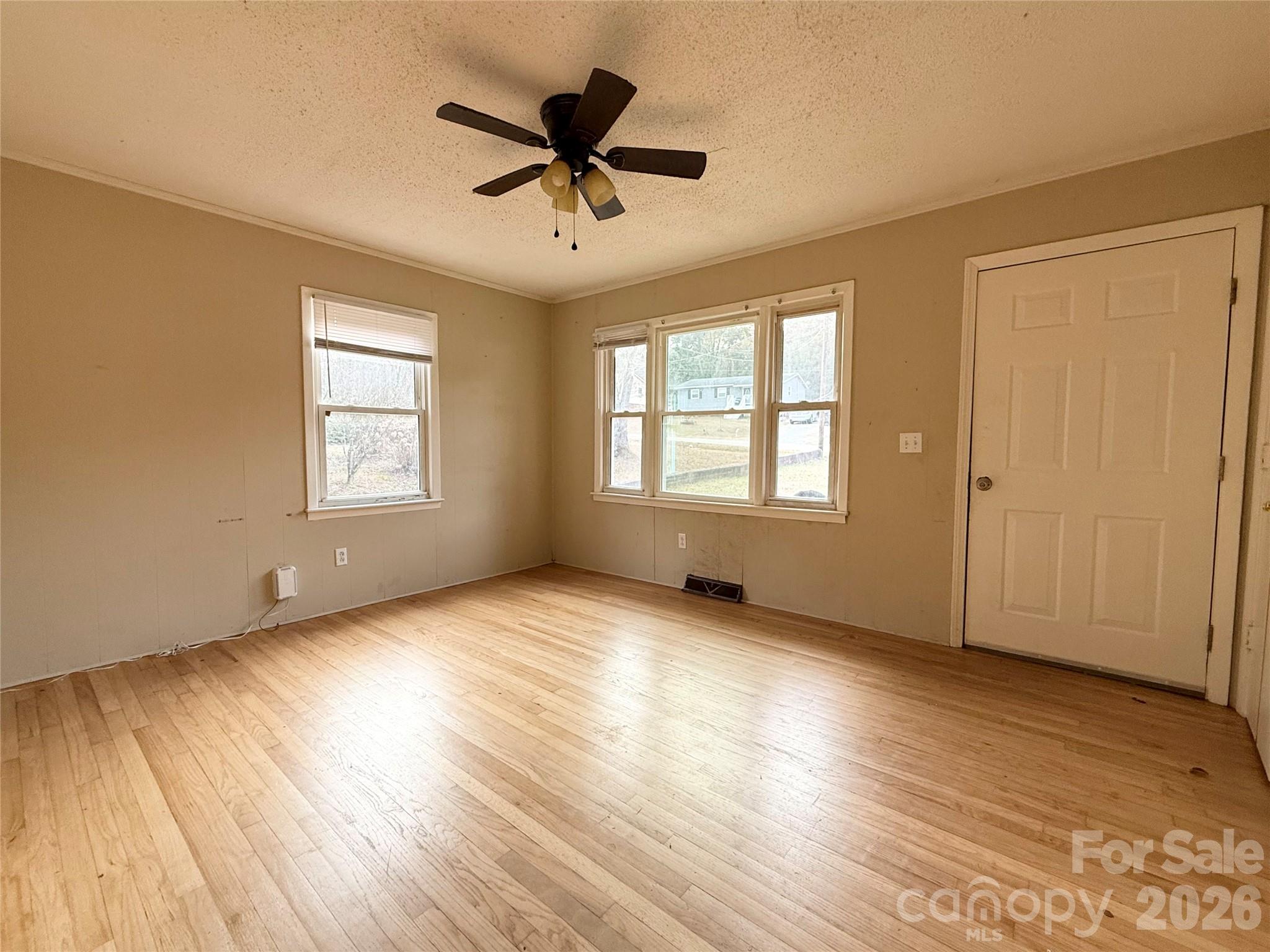 406 North Rutherford Street Wadesboro, NC 28170 - Photo 5 of 9 an empty room with wooden floor and windows
