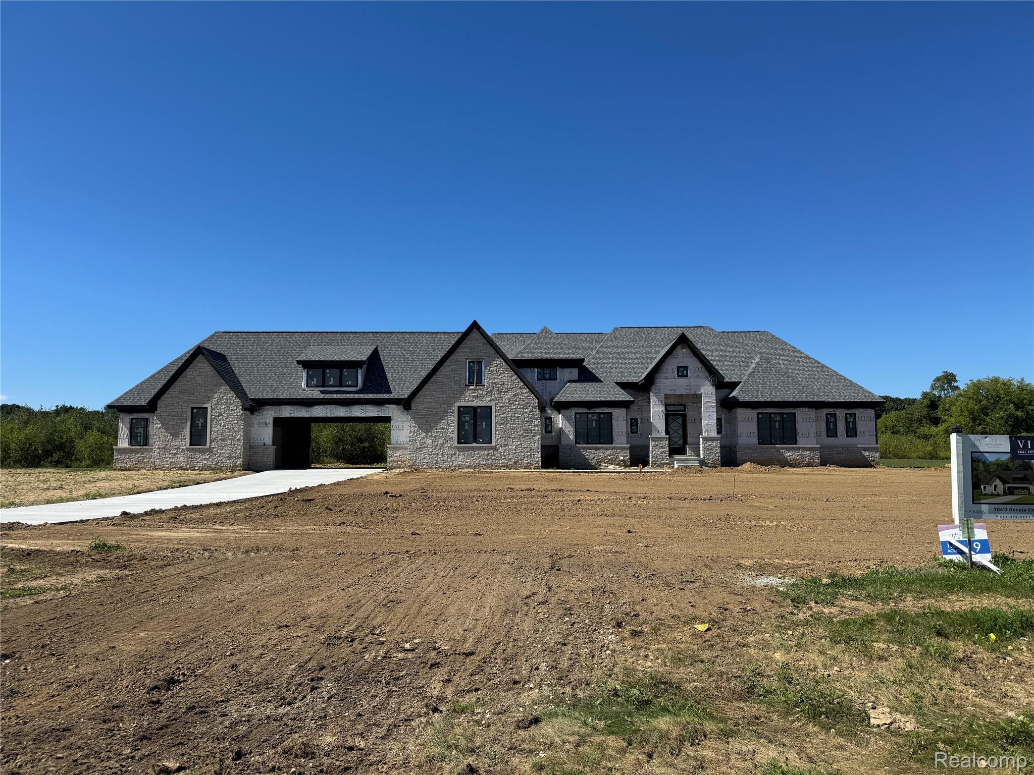 70413 Renata Court Romeo, MI 48065 - Photo 5 of 51 Expansive stone exterior with black-framed windows and multiple gables
