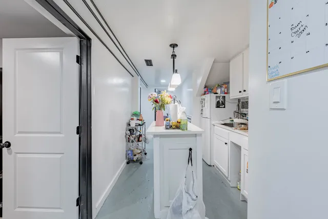 a kitchen that has cabinets a sink dishwasher and a dining table with wooden floor
