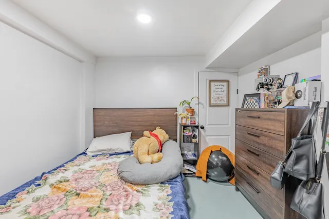 a view of a brick house with many windows plants and large trees
