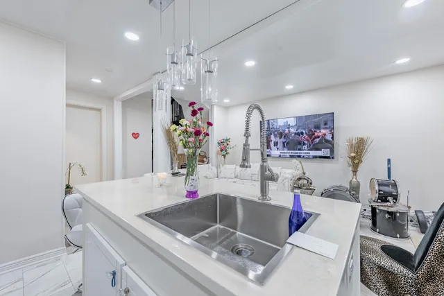 a kitchen with granite countertop a sink and a stove top oven with wooden floor