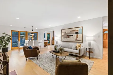 a dining room with furniture a chandelier and wooden floor