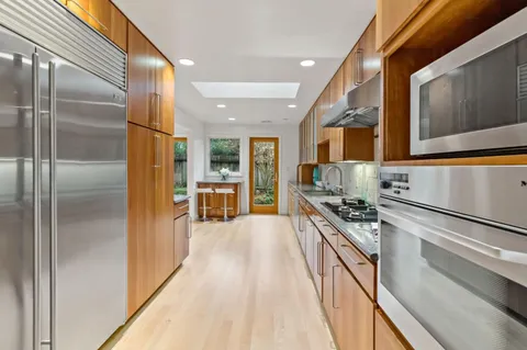 a kitchen with stainless steel appliances a stove refrigerator and microwave