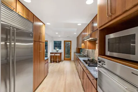 a kitchen with stainless steel appliances granite countertop a refrigerator and a stove
