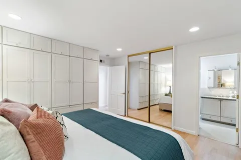 a bedroom with a large bed and a chandelier