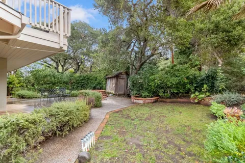 an aerial view of a house with garden space and parking