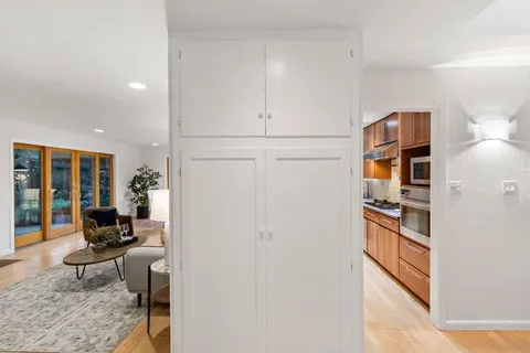 a dining room with wooden floor a chandelier a glass table and chairs