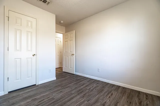a view of an empty room with wooden floor