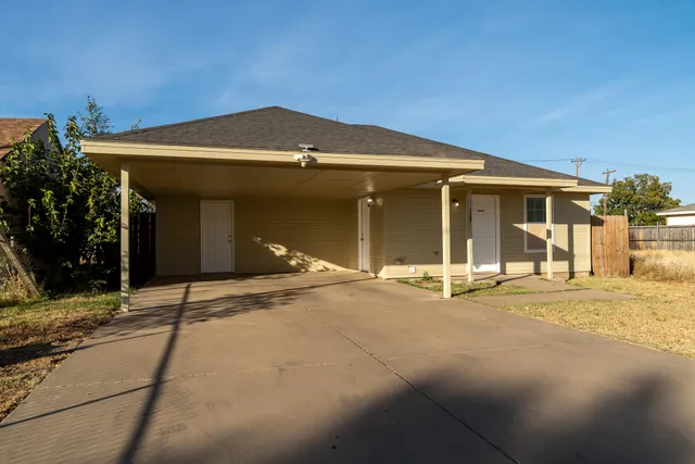 a view of a house with a patio and a yard