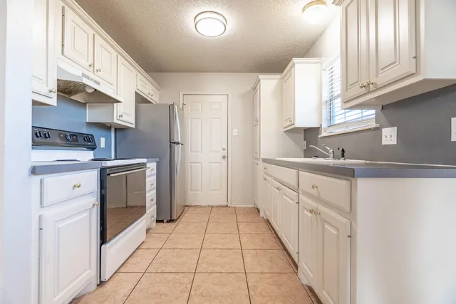 a kitchen with white cabinets and white appliances