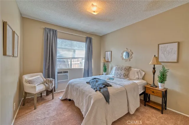 a bed sitting in a bedroom next to a window and a lamp