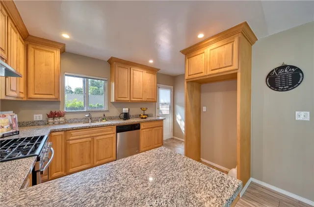 a kitchen with a sink a stove cabinets and wooden floor