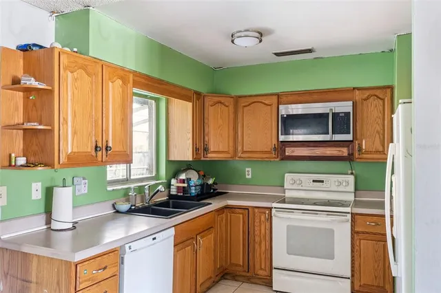 a kitchen with stainless steel appliances a sink a stove cabinets and a window
