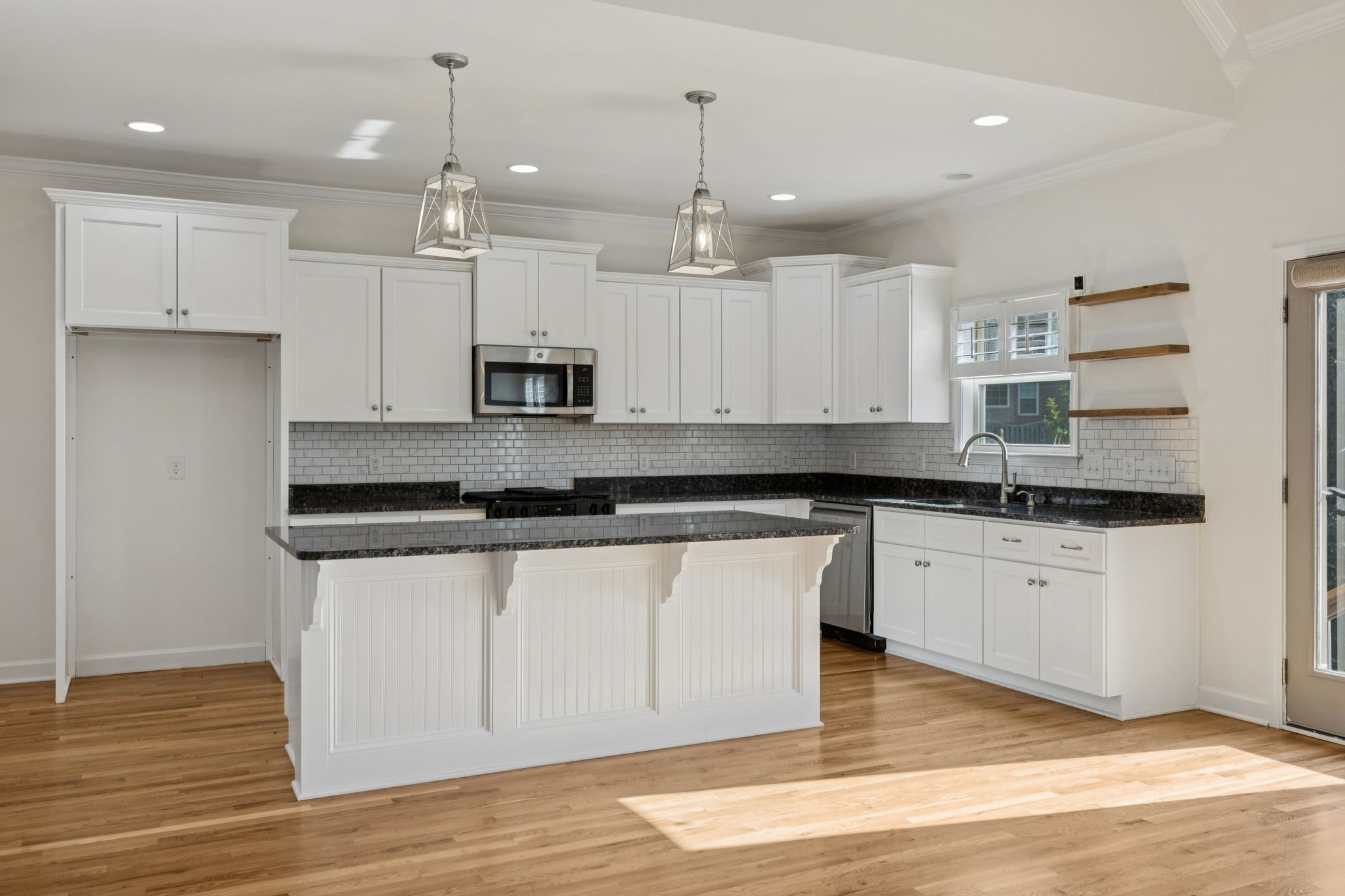 2002 Virgle Circle Spring Hill, TN 37174 - Photo 11 of 44 a kitchen with kitchen island granite countertop wooden floors white cabinets and stainless steel appliances