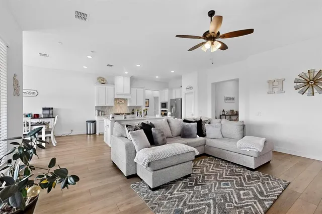 a living room with furniture and a wooden floor