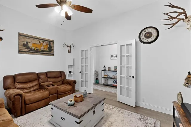 a living room with furniture a clock on wall and a table