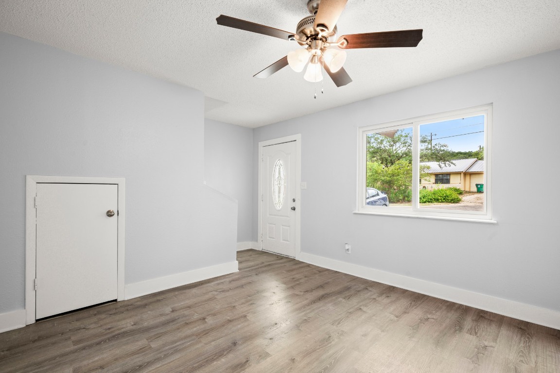 10905 Elm Street Jonestown, TX 78645 - Photo 11 of 26 a view of an empty room with wooden floor and a window