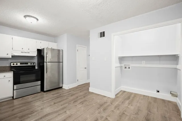 a view of kitchen with wooden floor electronic appliances and electronic appliances