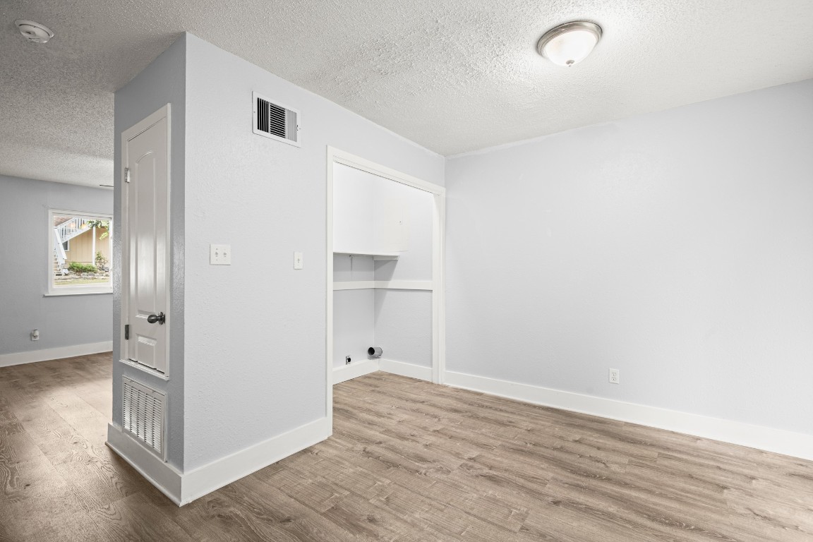 10905 Elm Street Jonestown, TX 78645 - Photo 17 of 26 an empty room with wooden floor and windows