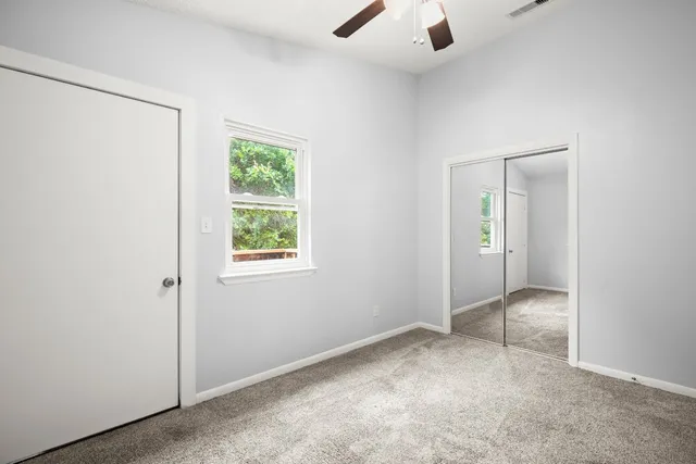 an empty room with windows and closet