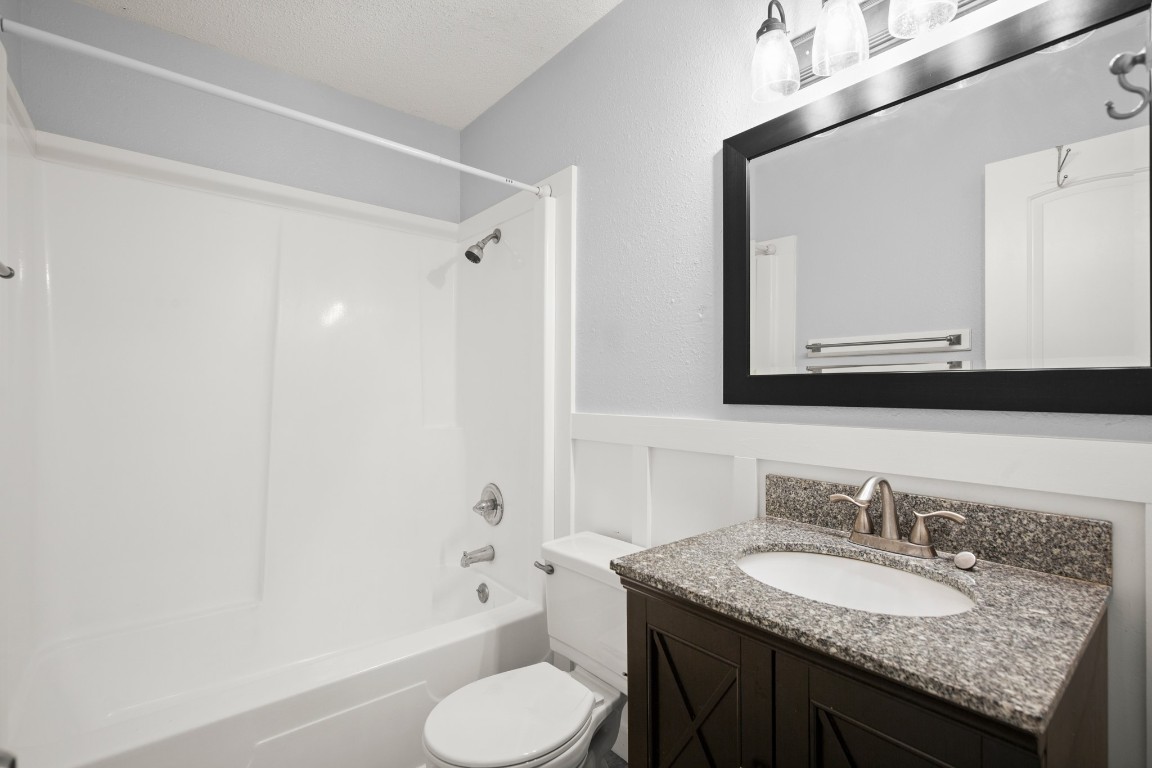 10905 Elm Street Jonestown, TX 78645 - Photo 24 of 26 a bathroom with a granite countertop sink toilet and shower