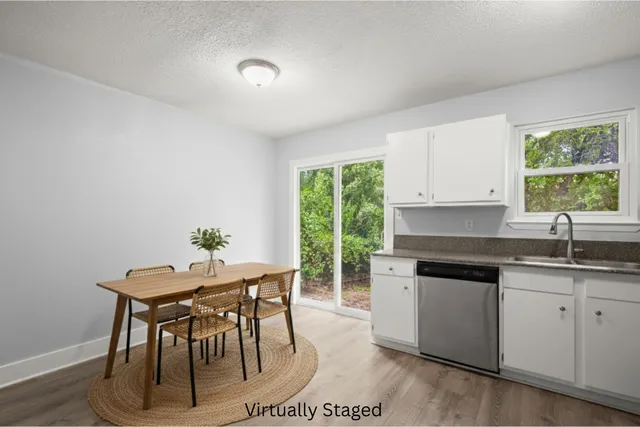 a kitchen with granite countertop a table chairs stove and cabinets