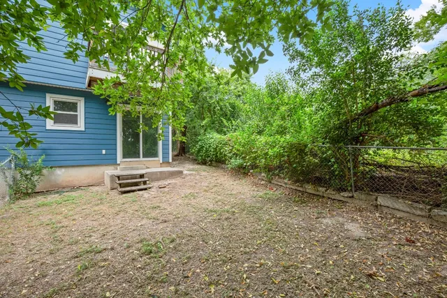 a view of a backyard with a garden and outdoor seating