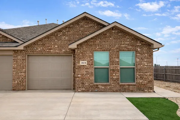 a front view of a house with a garden and plants
