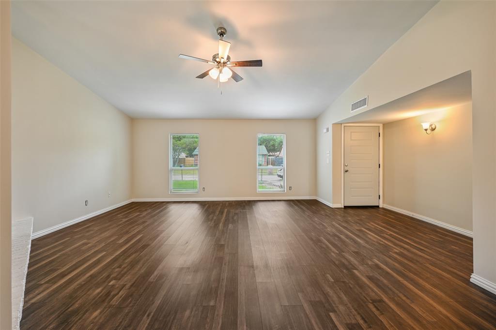 7318 Emory Oak Lane Dallas, TX 75249 - Photo 20 of 28 Spacious room featuring wood-finish flooring, vaulted ceiling, and a ceiling fan with integrated lighting