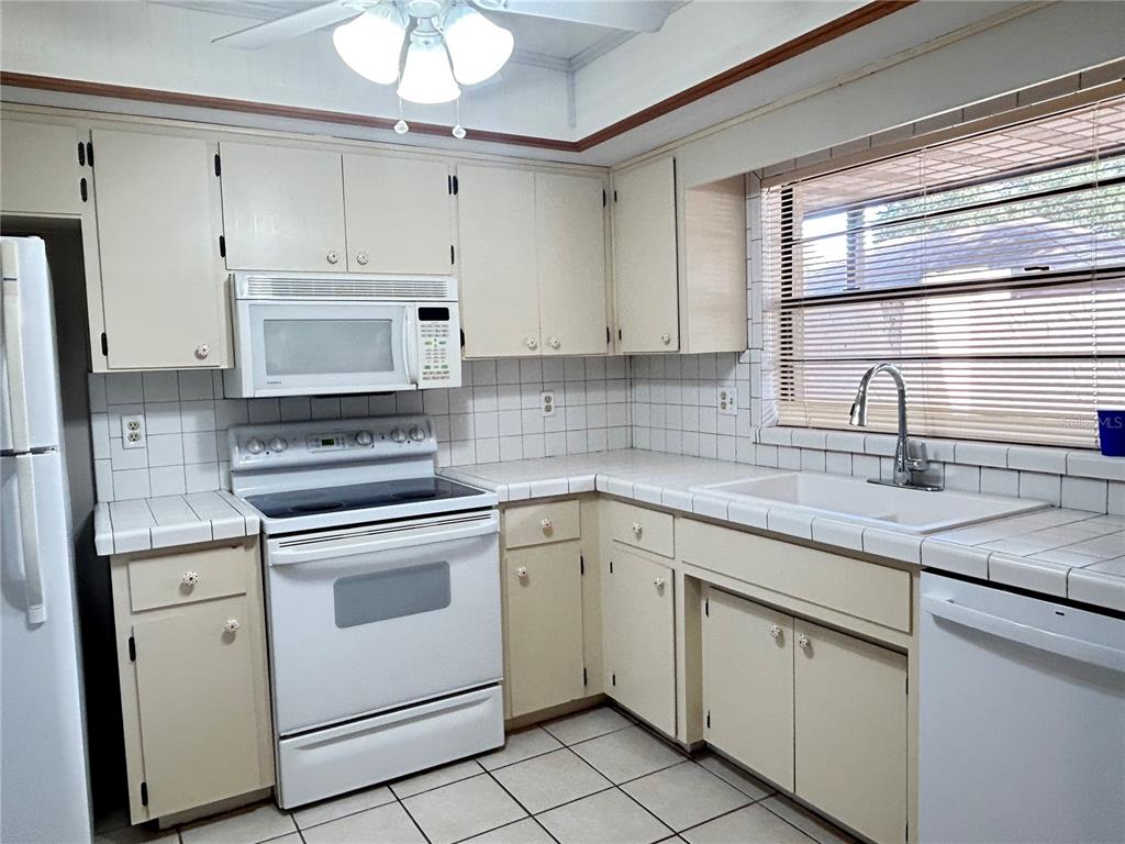 2274 Firestone Place Winter Haven, FL 33884 - Photo 11 of 25 a kitchen with white cabinets appliances and a sink