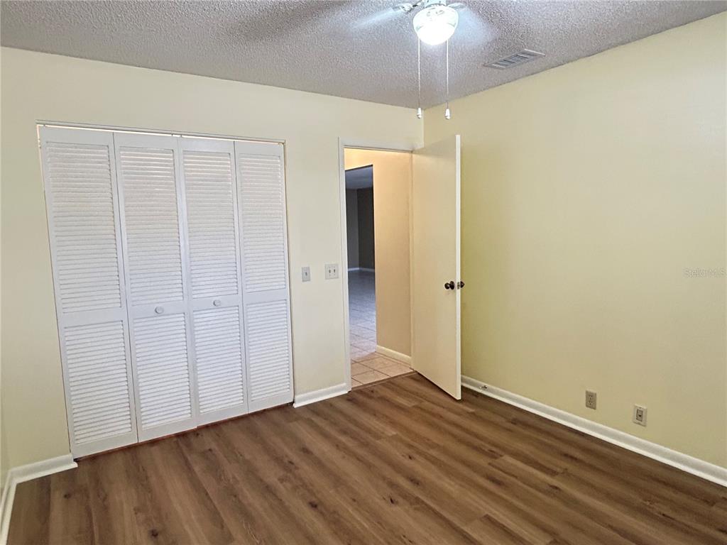 2274 Firestone Place Winter Haven, FL 33884 - Photo 23 of 25 an empty room with wooden floor chandelier fan and entryway