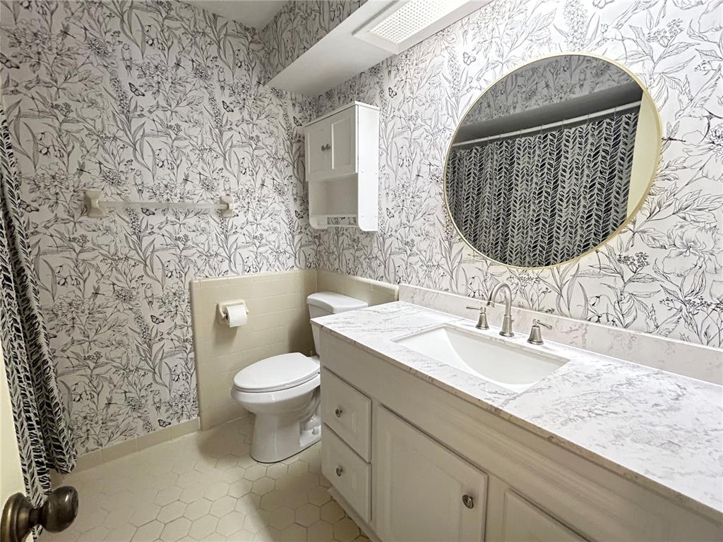 2274 Firestone Place Winter Haven, FL 33884 - Photo 25 of 25 a bathroom with a toilet sink vanity and mirror
