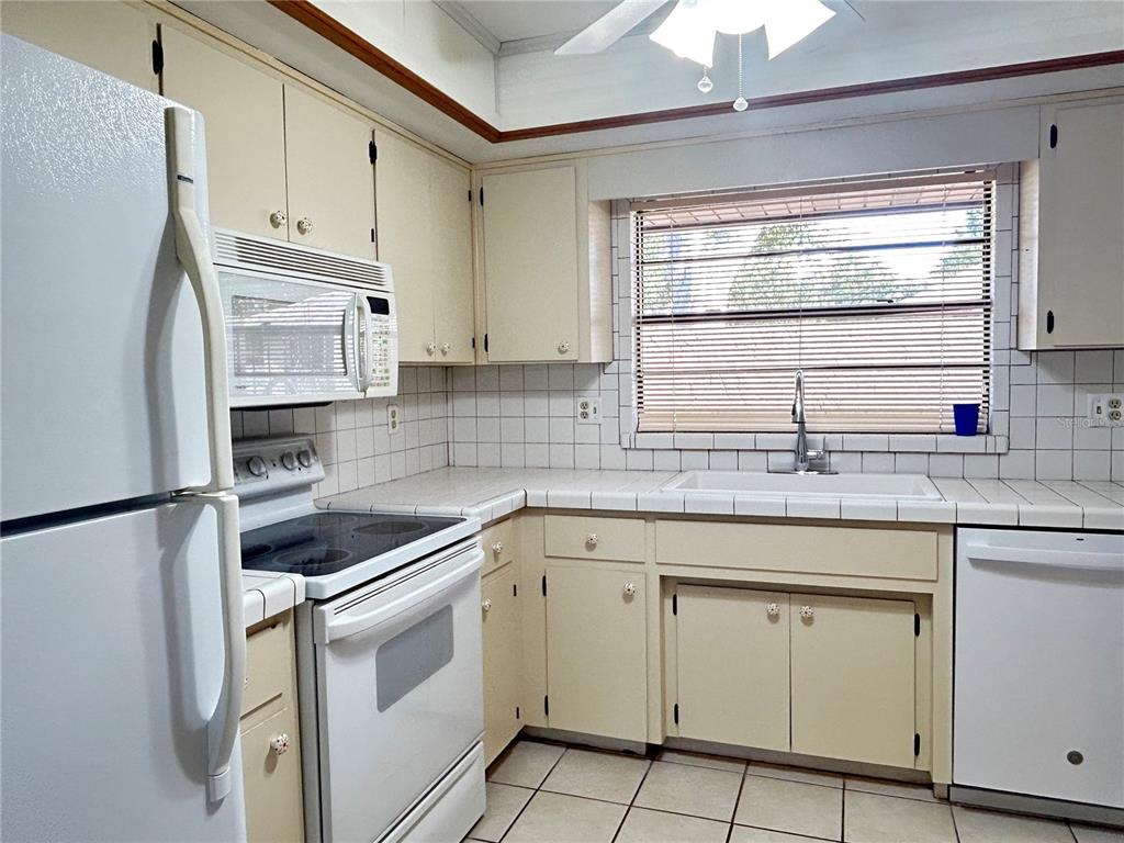 2274 Firestone Place Winter Haven, FL 33884 - Photo 9 of 25 a kitchen with white cabinets and white appliances