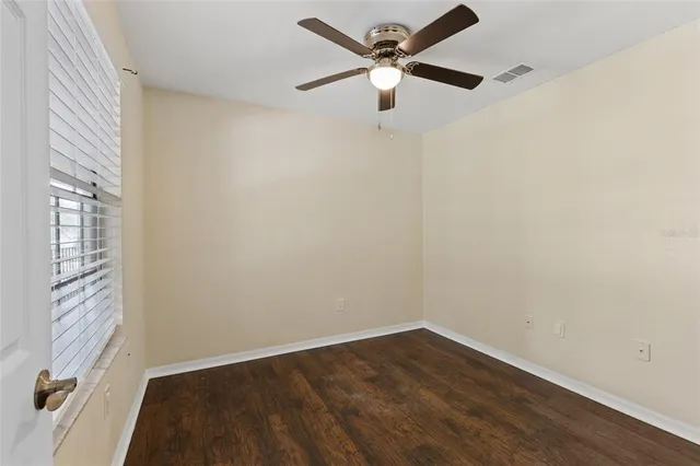 an empty room with a window and a fan