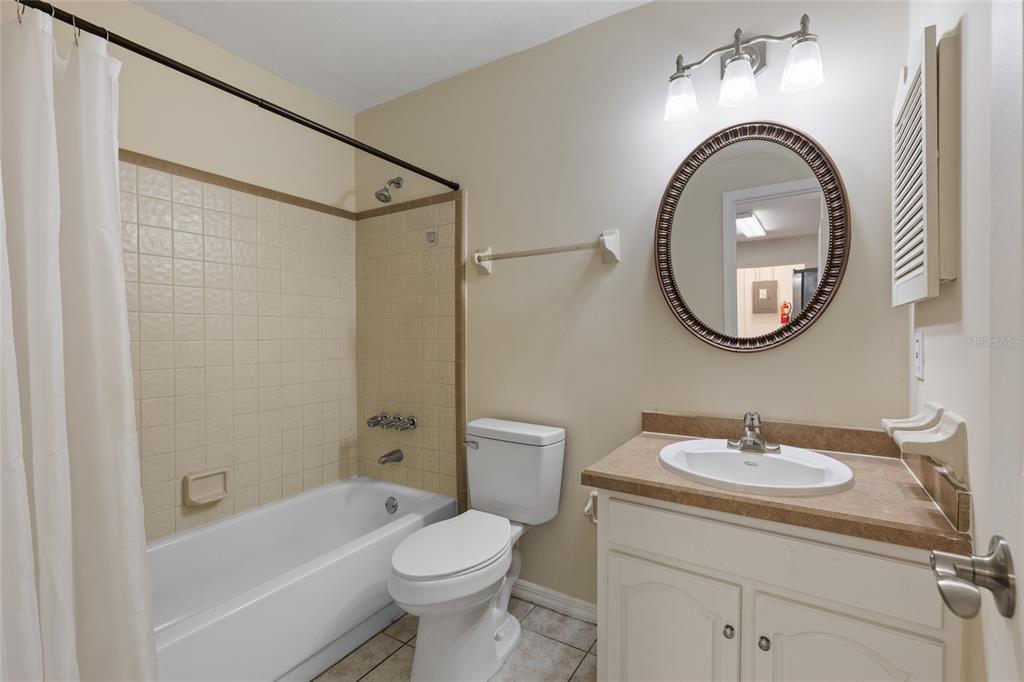 6400 Northwest 106th Place, Unit 20 Alachua, FL 32615 - Photo 25 of 40 a bathroom with a sink a mirror a toilet and a shower