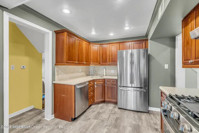 a kitchen with stainless steel appliances granite countertop a refrigerator a stove and a refrigerator