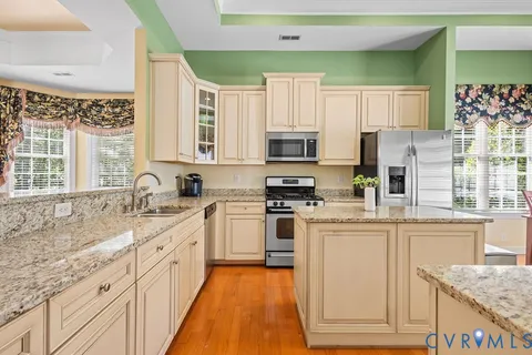 a kitchen with stainless steel appliances granite countertop a stove a sink and a microwave