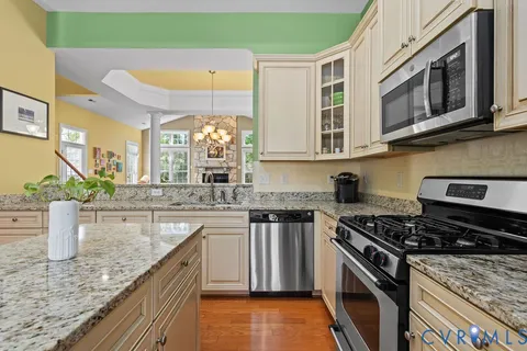 a kitchen with stainless steel appliances granite countertop a sink stove and cabinets