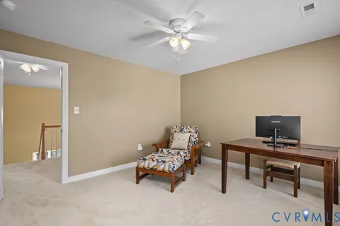 a view of a workspace with furniture and a window