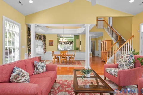 a living room with furniture floor to ceiling window and wooden floor