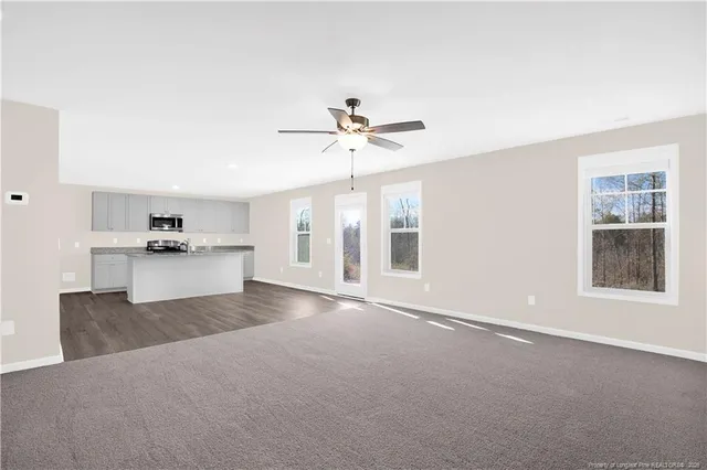 a view of an empty room with a kitchen
