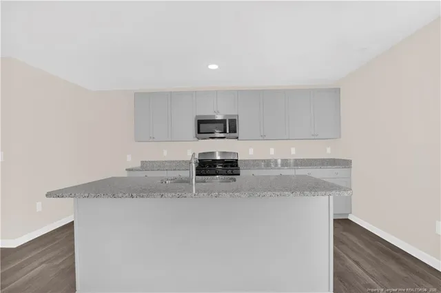 an empty room with windows and chandelier fan