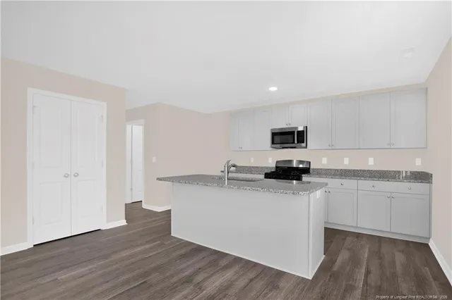 a kitchen with stainless steel appliances granite countertop a sink and stove top oven