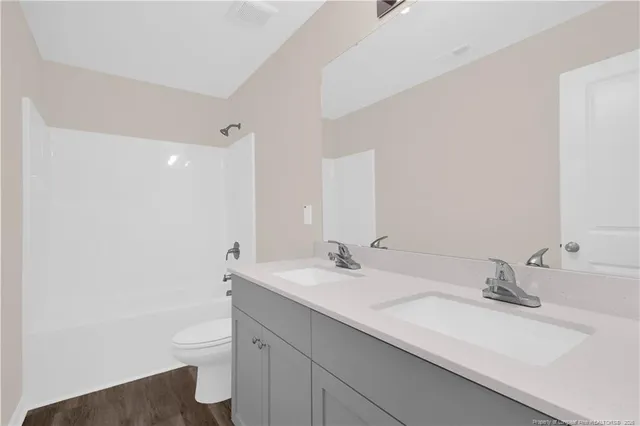 a bathroom with a sink a toilet and a large mirror