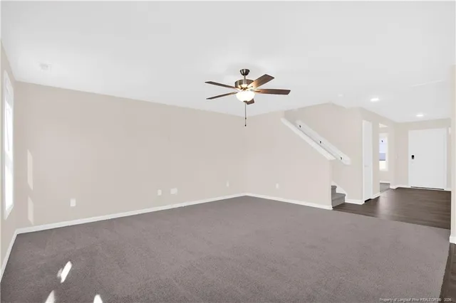 an empty room with fan and windows