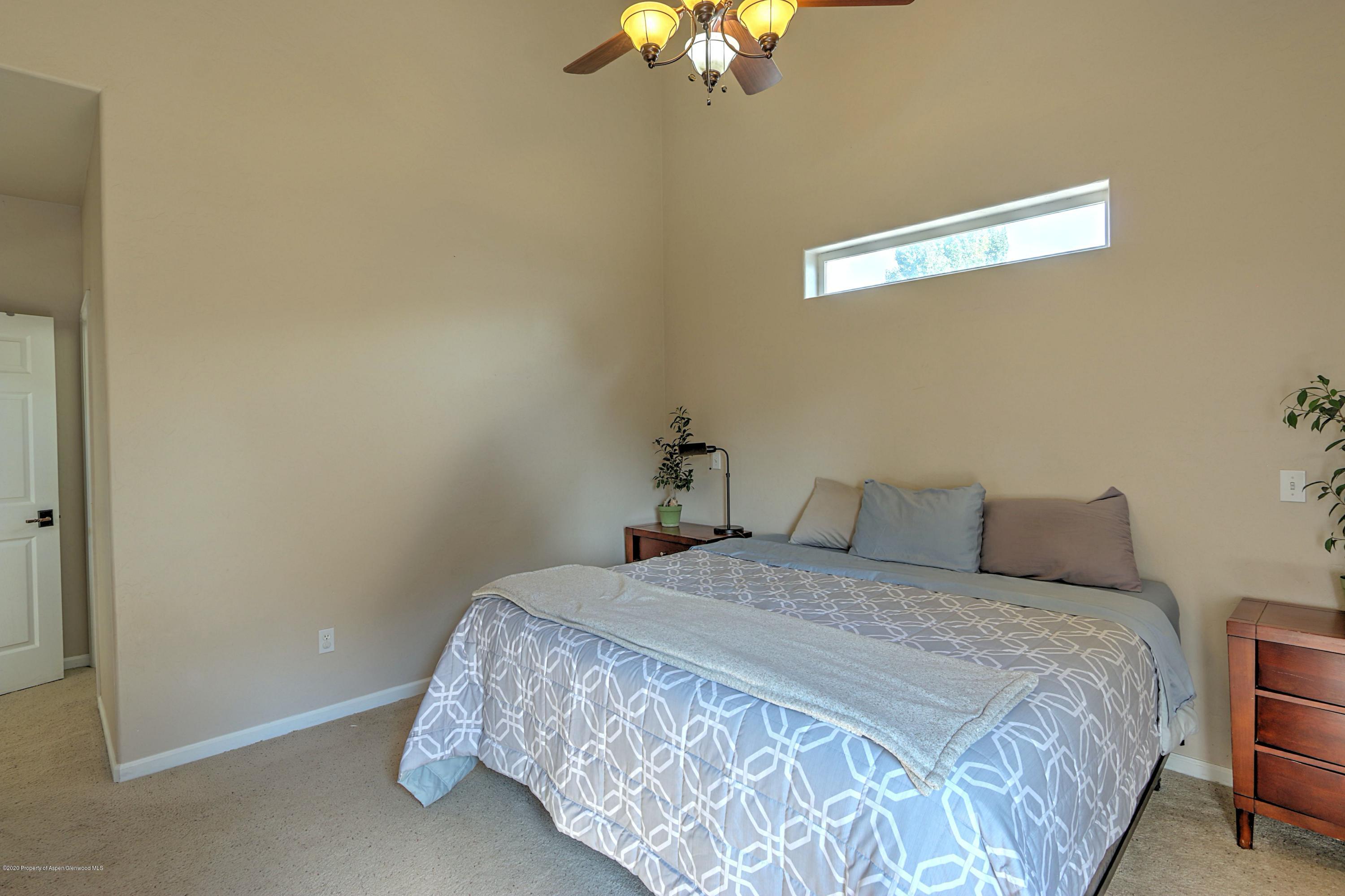 1600 Anvil View Avenue Rifle, CO 81650 - Photo 10 of 22 a bedroom with a bed and a chandelier