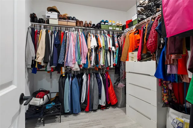 a view of walk in closet with clothes and shoes