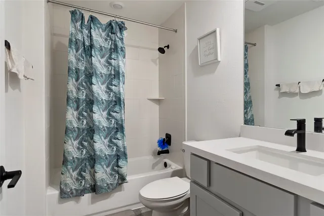 a bathroom with a sink a toilet and a shower curtain