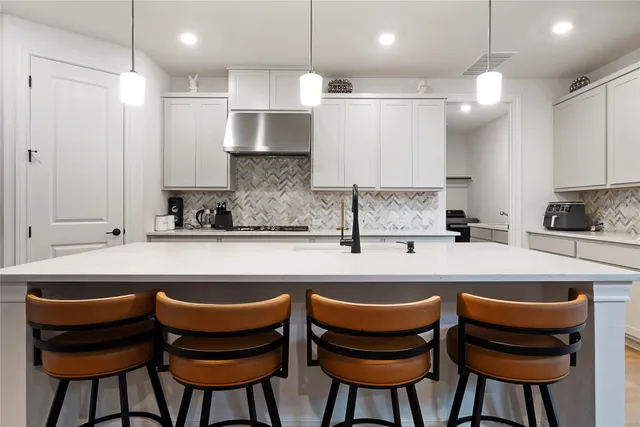 a kitchen with stainless steel appliances granite countertop a sink and a refrigerator